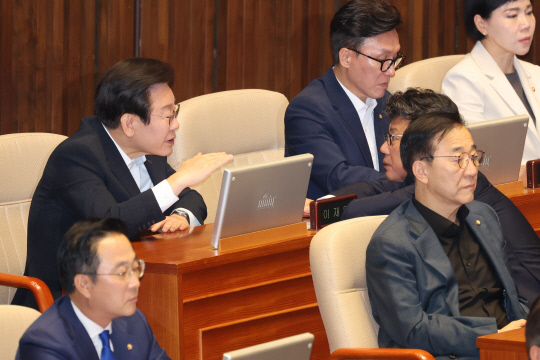 이재명 더불어민주당 대표가 지난 4일 오전 국회 본회의에서 진성준 정책위의장과 대화하고 있다. [연합뉴스 제공]